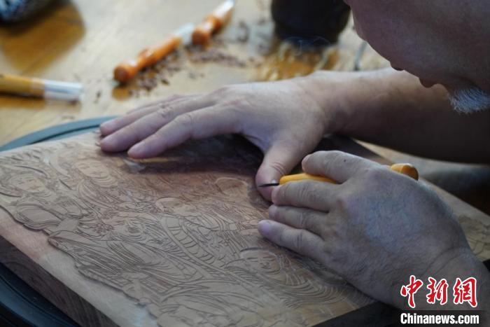 圖為徐晉林湊近木板，近距離制作雕版畫?！【琶赖┰?　攝