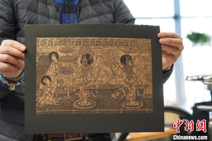 圖為手工書藝人展示敦煌雕版壁畫印刷品?！【琶赖┰?　攝