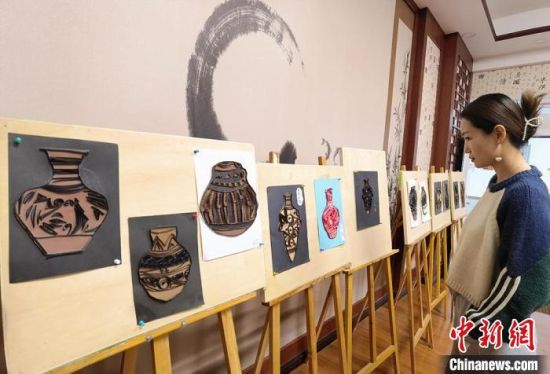 圖為學(xué)生用衍紙材料制作的彩陶紋飾?！⒂裉?攝