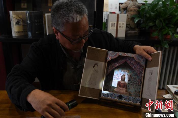 圖為讀者出版集團讀者晉林工作室獨立出品人徐晉林，展示互動性強的敦煌題材手工書。(資料圖) 楊艷敏 攝