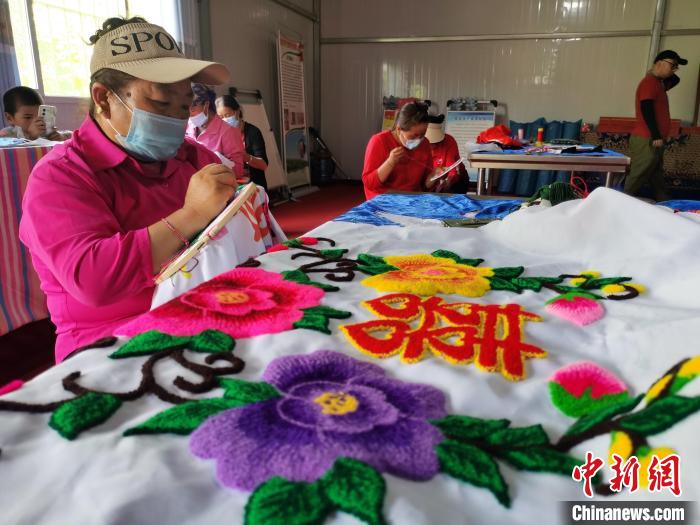 圖為婦女制作青繡?！?zhí)砀?攝