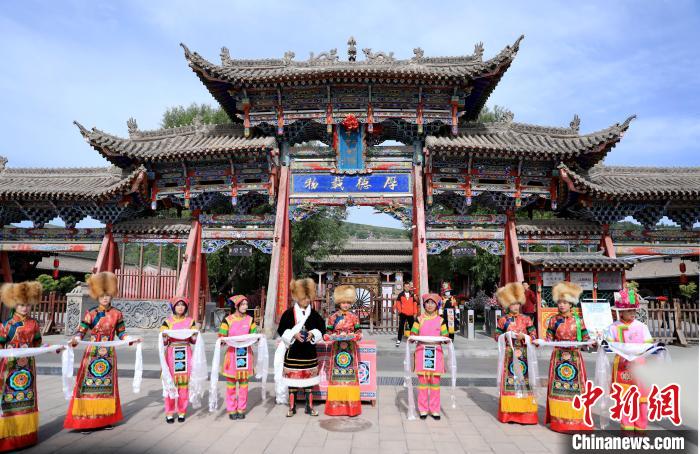 圖為身穿土族服飾的工作人員迎接訪客?！⊙Φ?攝