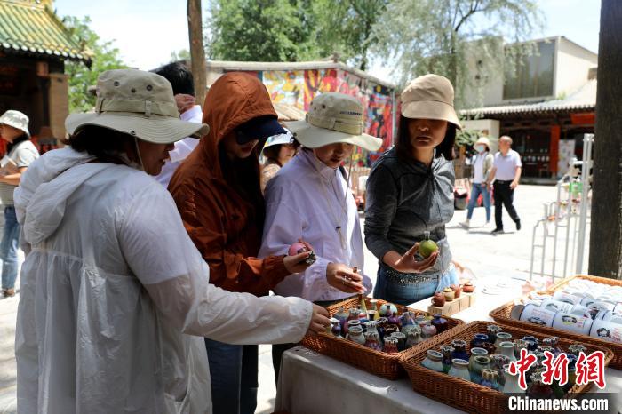 圖為民眾挑選手工藝產(chǎn)品?！⊙Φ?攝