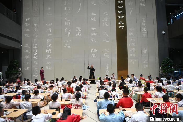 圖為9月7日，甘肅簡牘博物館開館儀式在蘭州舉行，小朋友們學(xué)習(xí)書寫簡牘中的文字。　中新社記者 九美旦增 攝