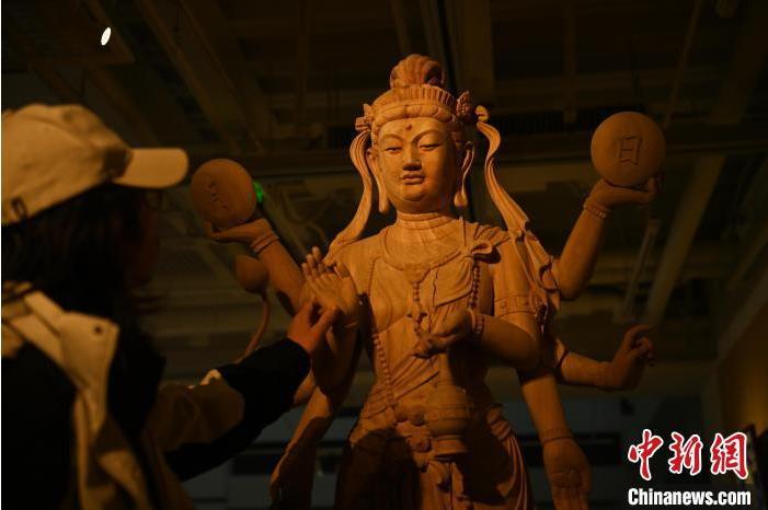 圖為季茂杰觀察自己創(chuàng)作的敦煌木雕。李亞龍 攝</p>
<p>