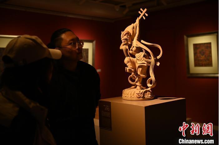 圖為季茂杰向參觀者介紹自己創(chuàng)作敦煌木雕的過(guò)程。李亞龍 攝</p>
<p>