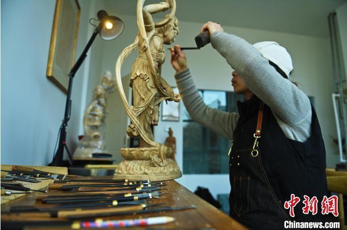 圖為季茂杰進(jìn)行敦煌元素的木雕創(chuàng)作。李亞龍 攝</p>
<p>