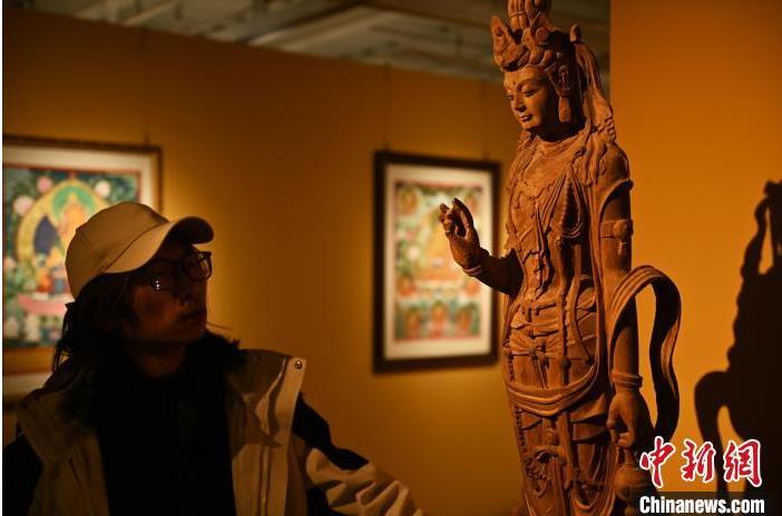 圖為季茂杰觀察自己創(chuàng)作的敦煌木雕。李亞龍 攝</p>
<p>