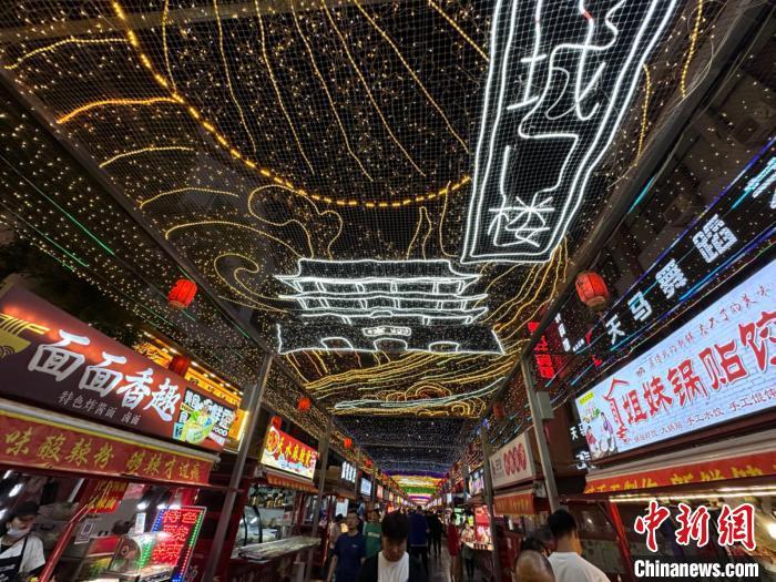 圖為明清街夜市燈光點(diǎn)亮具有武威文化元素的“涼州古城門”彩燈?！〈魑牟?攝</p><p>