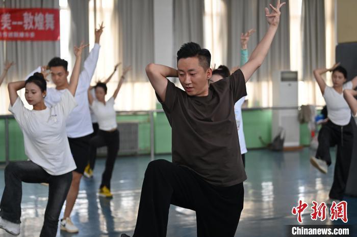 6月6日，在甘肅敦煌青年夜校課程中，青年學(xué)員學(xué)習(xí)敦煌舞課程。李亞龍 攝　　