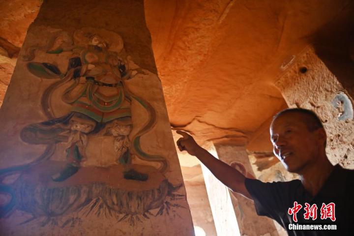 7月15日，甘肅省平?jīng)鍪袥艽h百里石窟長廊羅漢洞石窟內(nèi)，該窟文保員郭建平介紹窟內(nèi)石刻彩繪壁畫。郭建平家中三代人曾自發(fā)保護羅漢洞石窟。羅漢洞石窟遺存40余個窟龕，以北魏至清代風(fēng)格為主。中新社記者 李亞龍 攝</p>
<p>