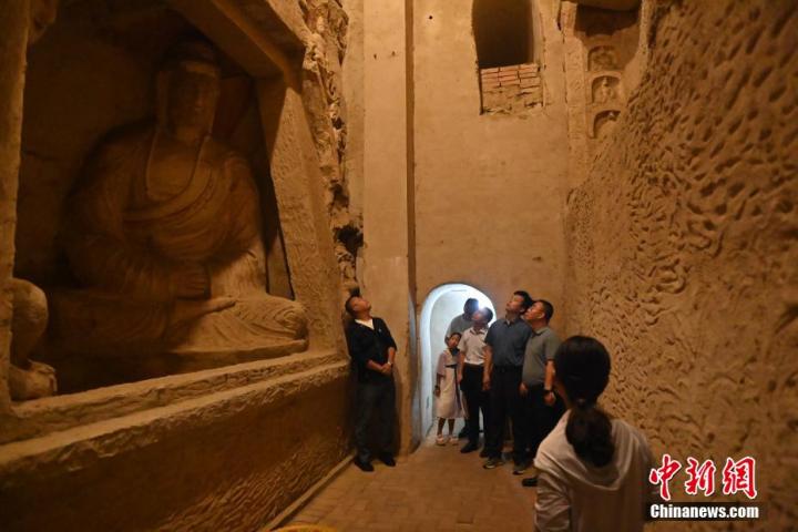 7月15日，游人參觀甘肅省平?jīng)鍪袥艽h百里石窟長廊中的王母宮石窟。百里石窟長廊位于涇川縣境內(nèi)，由512個石窟、5眼窟中石井組成，現(xiàn)存王母宮石窟、鳳凰山石窟、南石窟寺、丈八寺石窟、羅漢洞石窟、太山寺石窟等規(guī)模較大的石窟群，還有數(shù)量眾多的小石窟群。王母宮石窟又名千佛洞，該窟設(shè)計宏大，造像生動，窟內(nèi)擁有造像數(shù)百尊，是較為珍貴的佛教文化歷史遺存。中新社記者 李亞龍 攝</p>
<p>