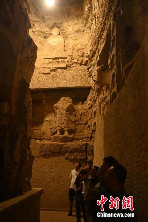 7月15日，游人參觀甘肅省平?jīng)鍪袥艽h百里石窟長廊中的王母宮石窟。百里石窟長廊位于涇川縣境內(nèi)，由512個石窟、5眼窟中石井組成，現(xiàn)存王母宮石窟、鳳凰山石窟、南石窟寺、丈八寺石窟、羅漢洞石窟、太山寺石窟等規(guī)模較大的石窟群，還有數(shù)量眾多的小石窟群。王母宮石窟又名千佛洞，該窟設(shè)計宏大，造像生動，窟內(nèi)擁有造像數(shù)百尊，是較為珍貴的佛教文化遺存。中新社記者 李亞龍 攝</p>
<p>