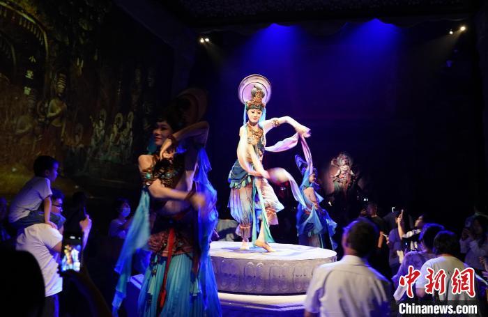 《樂動敦煌》是全球首部洞窟式沉浸體驗劇，利用真人與數(shù)字影像虛實(shí)交換實(shí)現(xiàn)沉浸式體驗。圖為2023年8月28日晚，《樂動敦煌》演出。(資料圖)中新社記者 毛建軍 攝