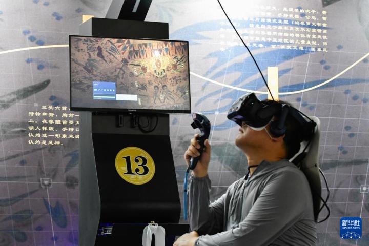 7月22日，游客借助VR設(shè)備沉浸式游覽莫高窟第285窟虛擬場景。新華社記者 郎兵兵 攝